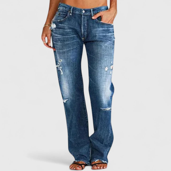 Women's low rise straight leg jeans in distressed blue denim with authentic rip-and-fade detailing
