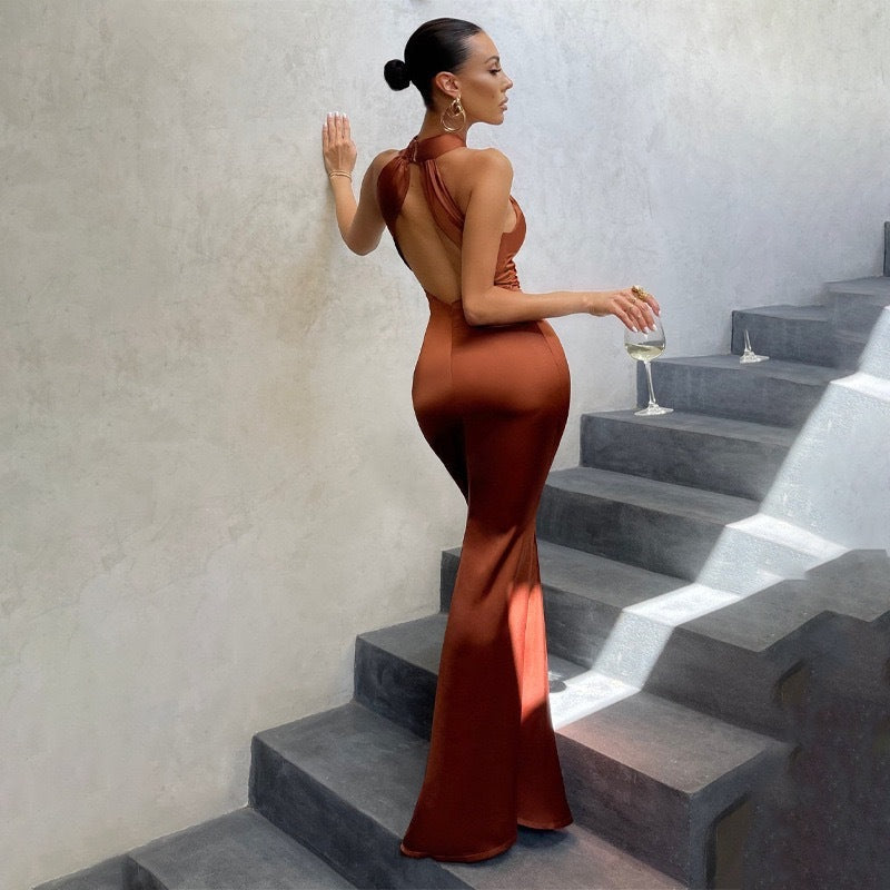 Elegant black fishtail dress with open back, fitted cut, and dramatic flared hem for special occasions