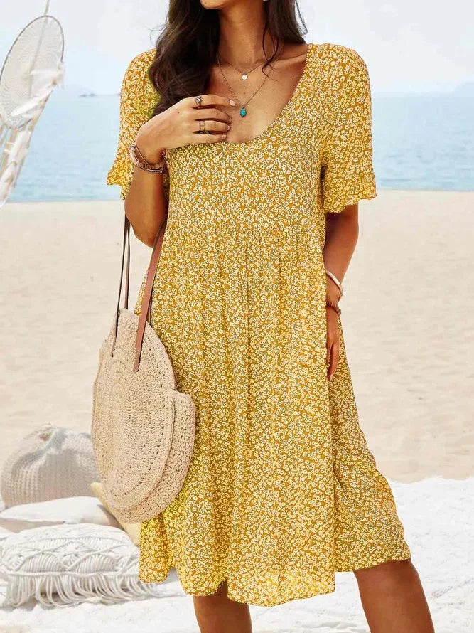 Women's navy ditsy floral smock dress with V-neck, flutter sleeves, smocked bodice, and tiered flowy hem