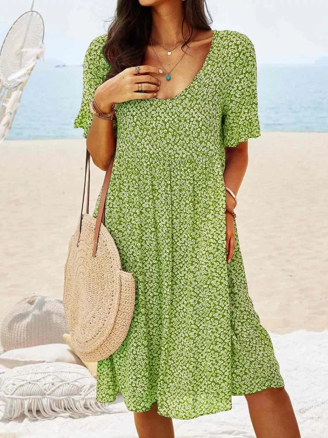 Women's navy ditsy floral smock dress with V-neck, flutter sleeves, smocked bodice, and tiered flowy hem