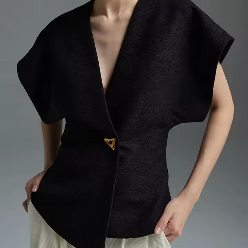 Sculptured wrap top in neutral tone with folded sleeves, defined waist, and gold-tone clasp closure