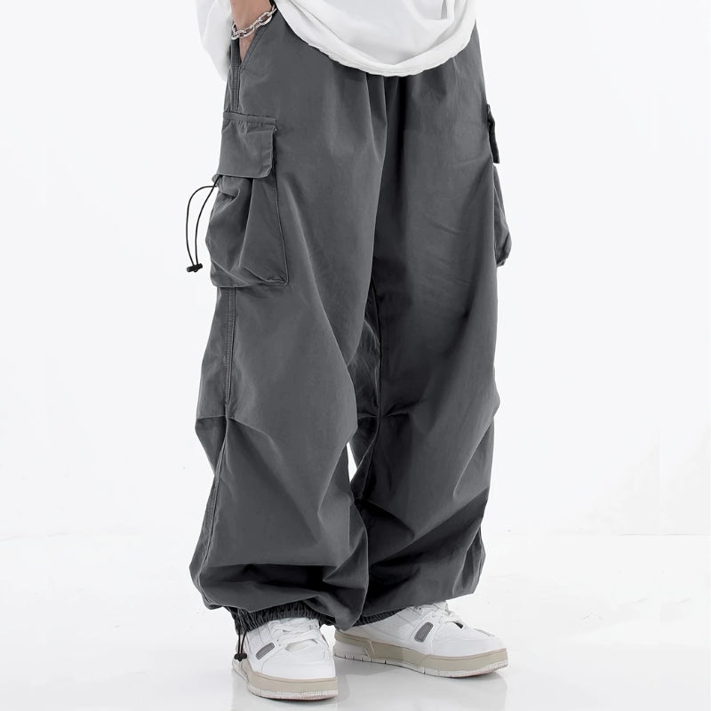 Malvor wide-leg cargo pants in neutral tones with drawstring cuffs and utility pockets for urban style