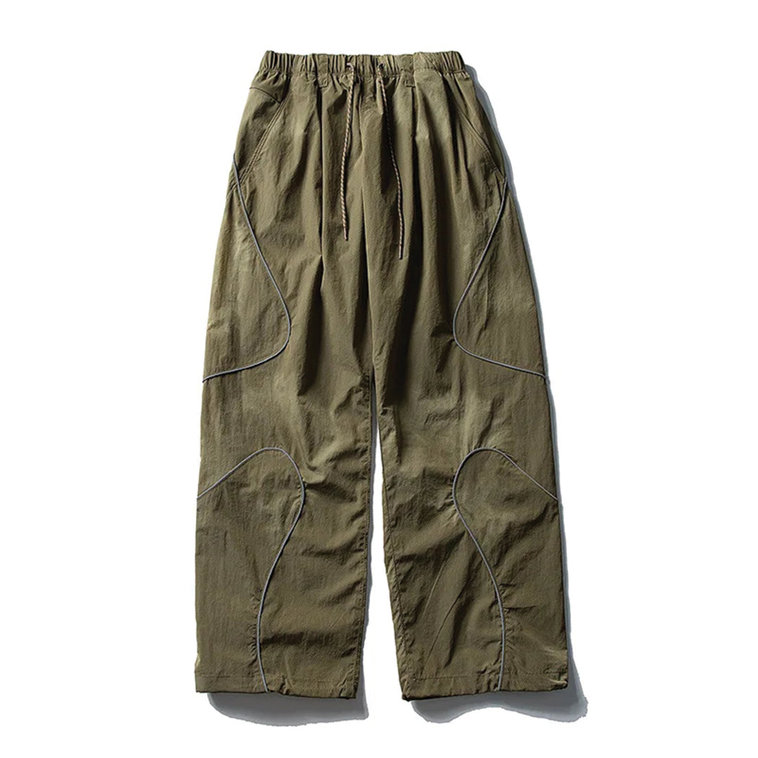 Black wide-leg nylon trousers with curved reflective stripes, drawstring waist, relaxed athletic fit