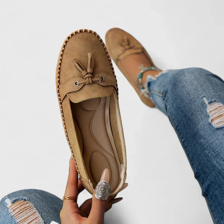 Sage green suede slip-on loafer flats with delicate bow and tassel detail for women