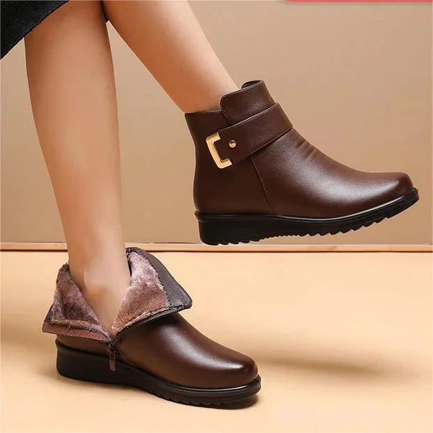 Women's brown leather winter boots with faux fur lining and decorative strap detail