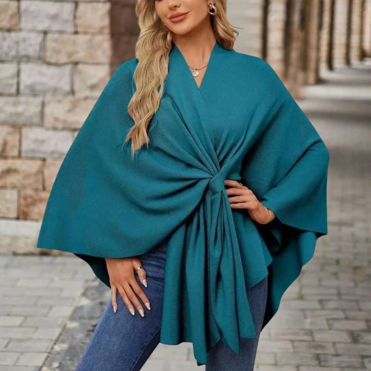 Elegant draped poncho with chic front knot in soft neutral tones, flowing silhouette layering piece