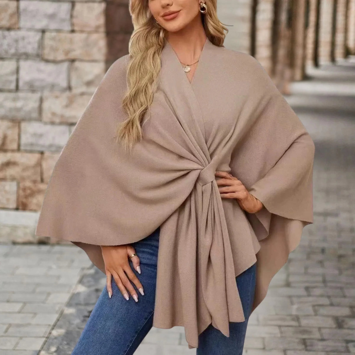 Elegant draped poncho with chic front knot in soft neutral tones, flowing silhouette for effortless style