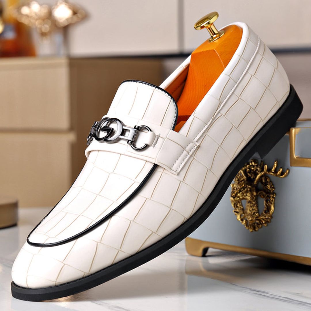 Men's textured leather loafers with polished finish and sleek metal buckle accent for formal wear