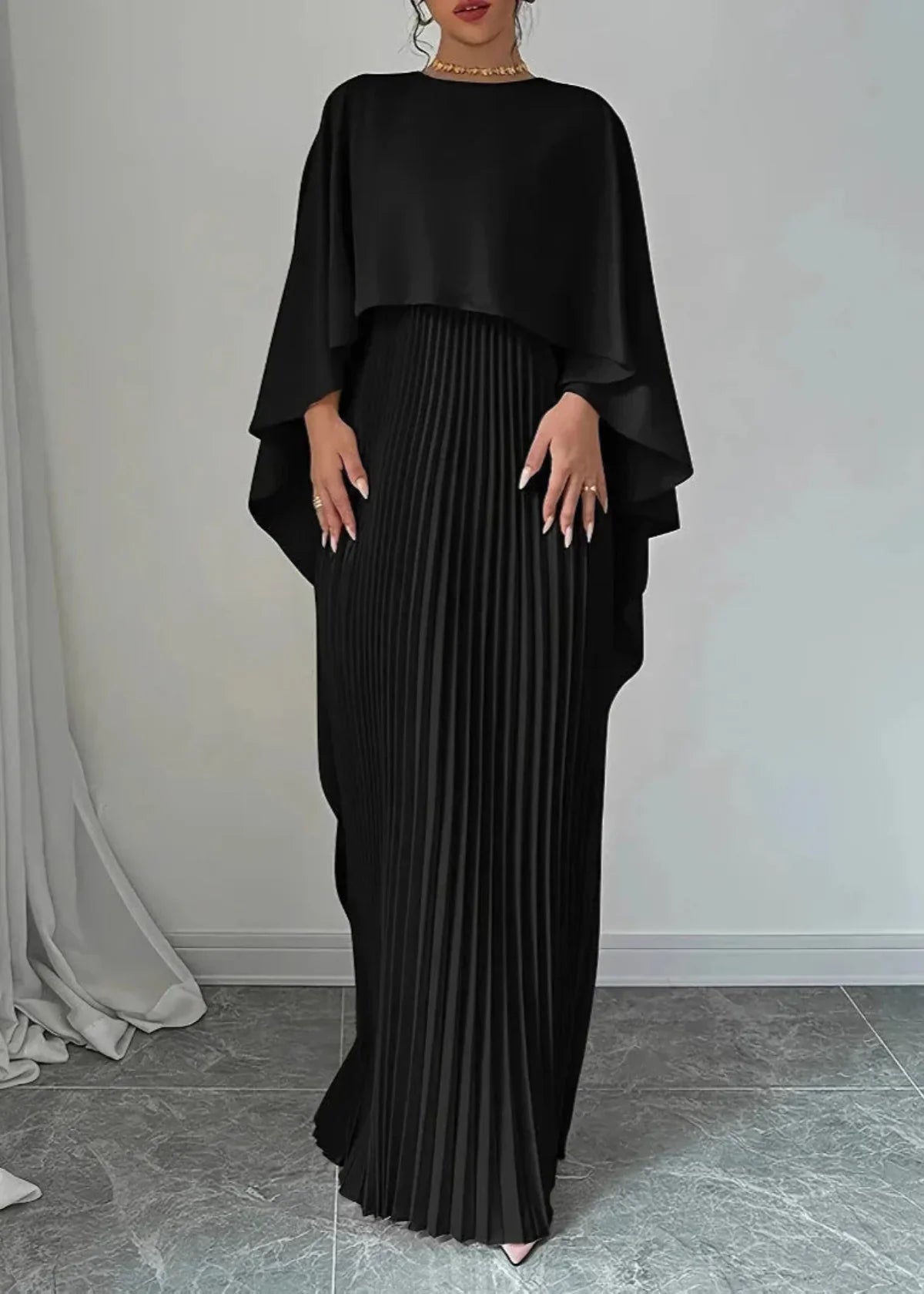 Women's pleated cape overlay maxi dress in elegant evening style with structured pleats and draped shoulders