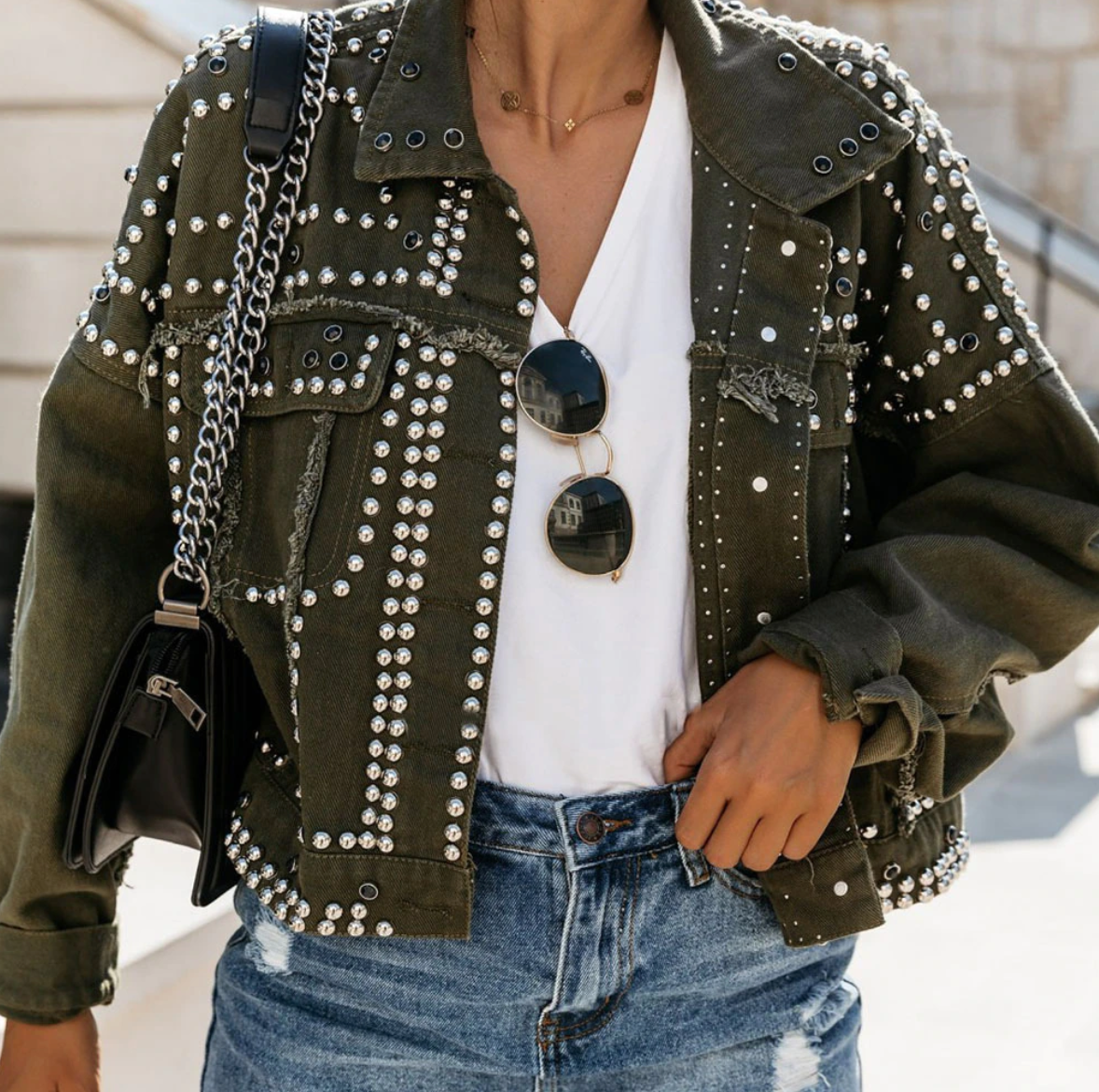 Women's black cropped jacket with all-over silver metallic studs, bold hardware streetwear style