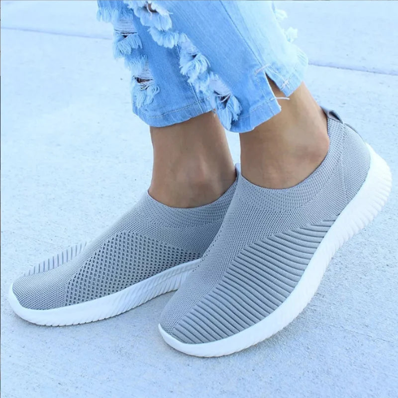 Women's white breathable slip-on sneakers with knit upper, lightweight sock-like fit for casual wear