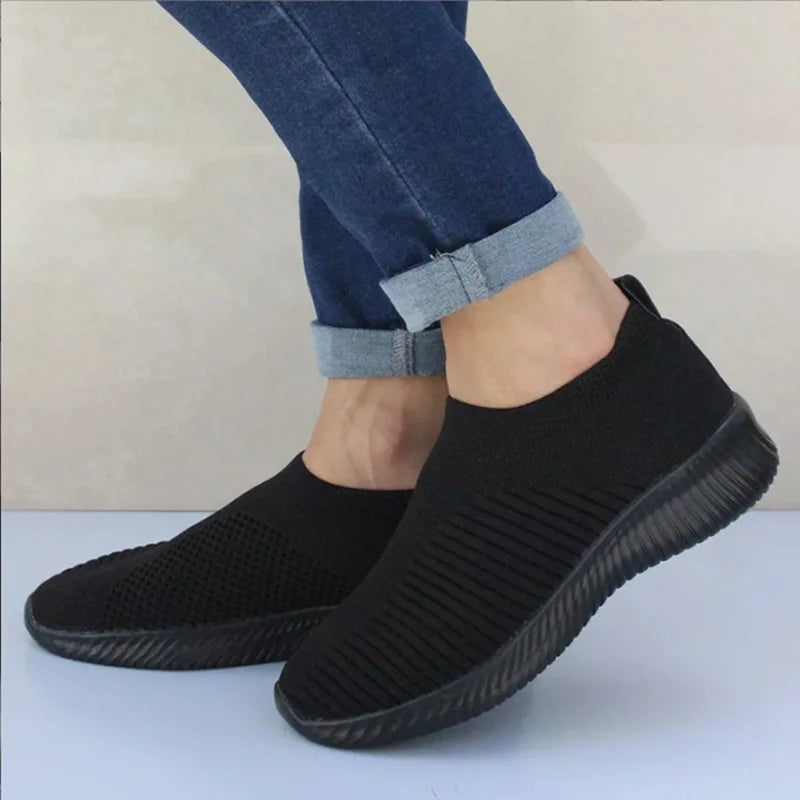 Women's white breathable slip-on knit sneakers with lightweight rubber sole and sock-like fit
