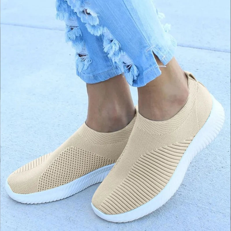 Women's white breathable slip-on knit sneakers with lightweight flexible rubber sole for casual wear