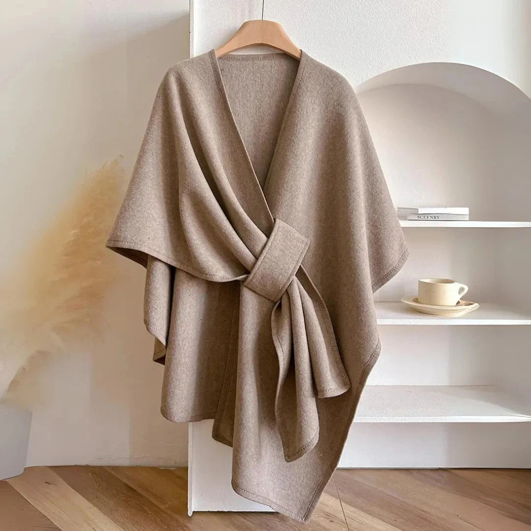Beige loose knitted fleece cape with waist-cinching hook and draped shoulder silhouette
