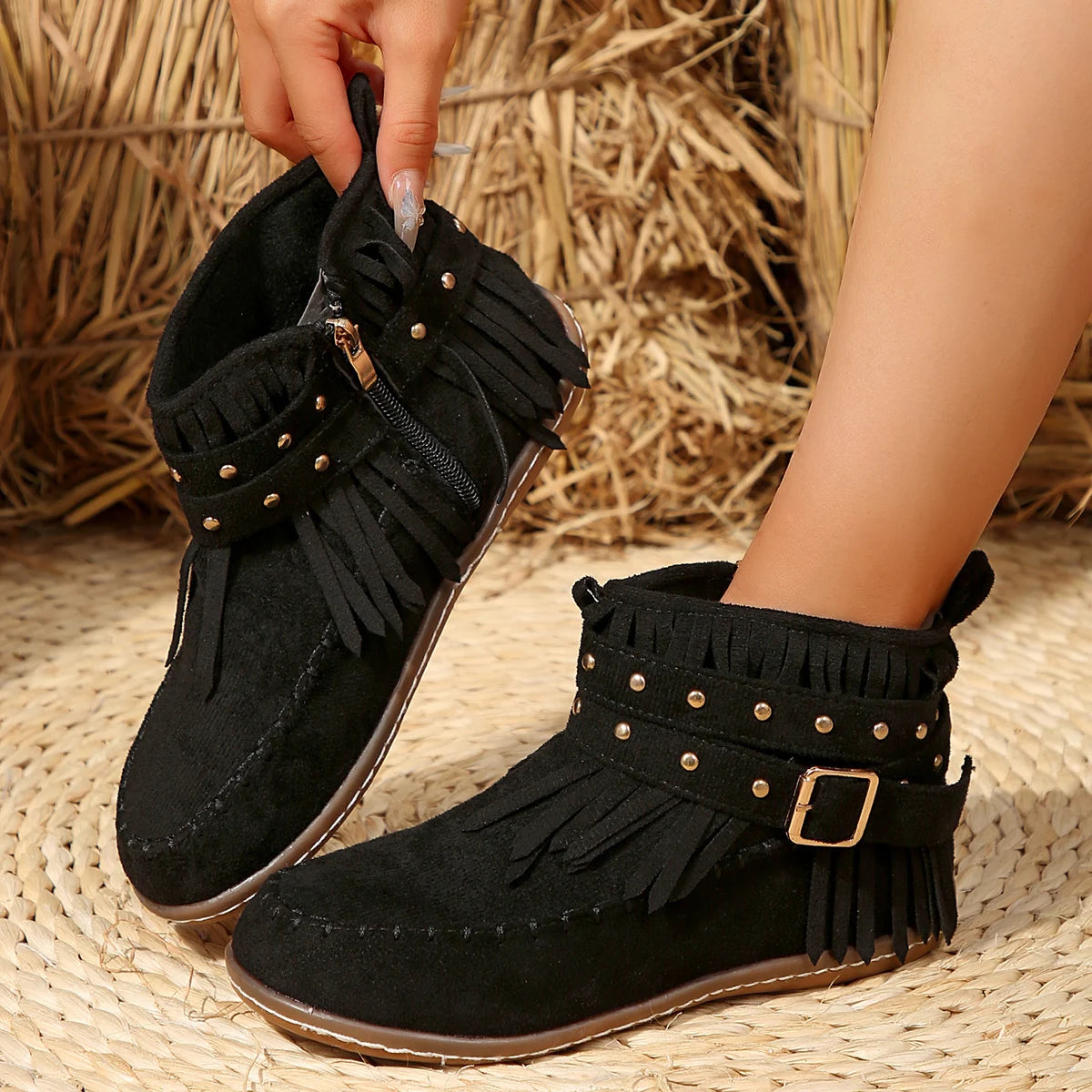 Black ankle boots with Western buckle strap, fringe collar, and studded detail for women