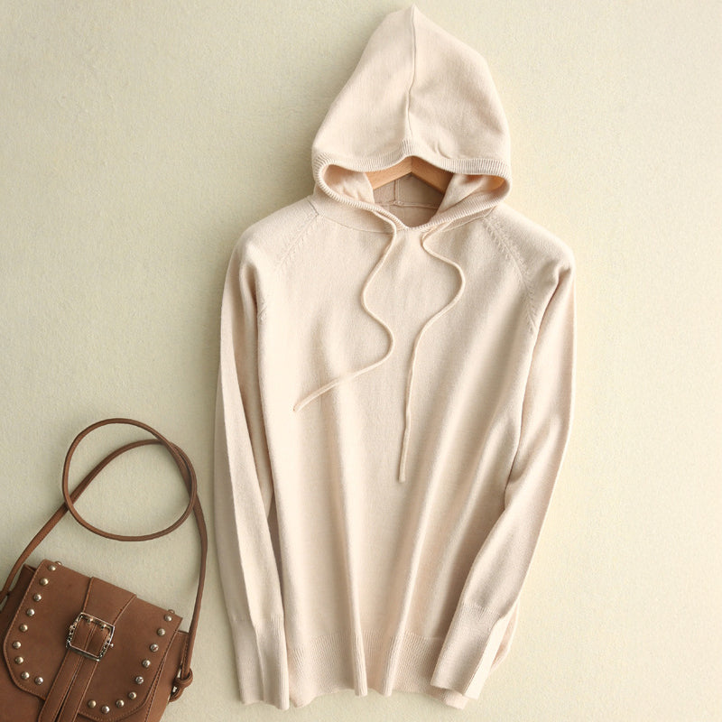 Soft knit hoodie in neutral tone, relaxed minimalist silhouette with subtle drawstrings and fluid drape