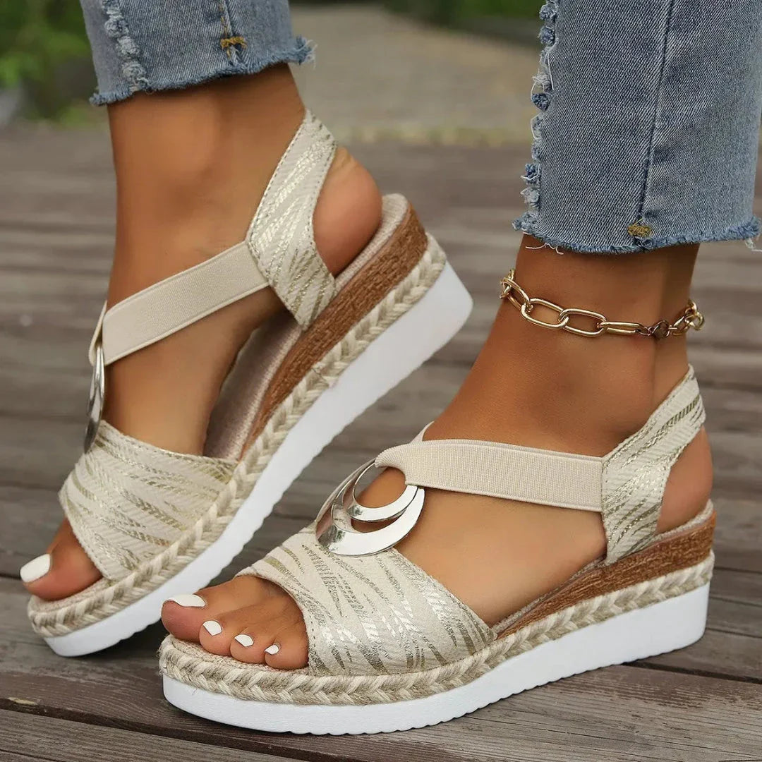 Open-toe wedge sandals with jute-wrapped platform, metallic crescent hardware, and elastic slingback straps