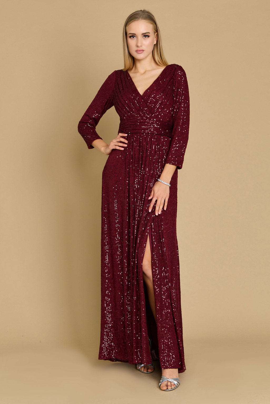 Floor-length silver sequin prom gown with long sleeves, deep V-neckline, hand-beaded detailing