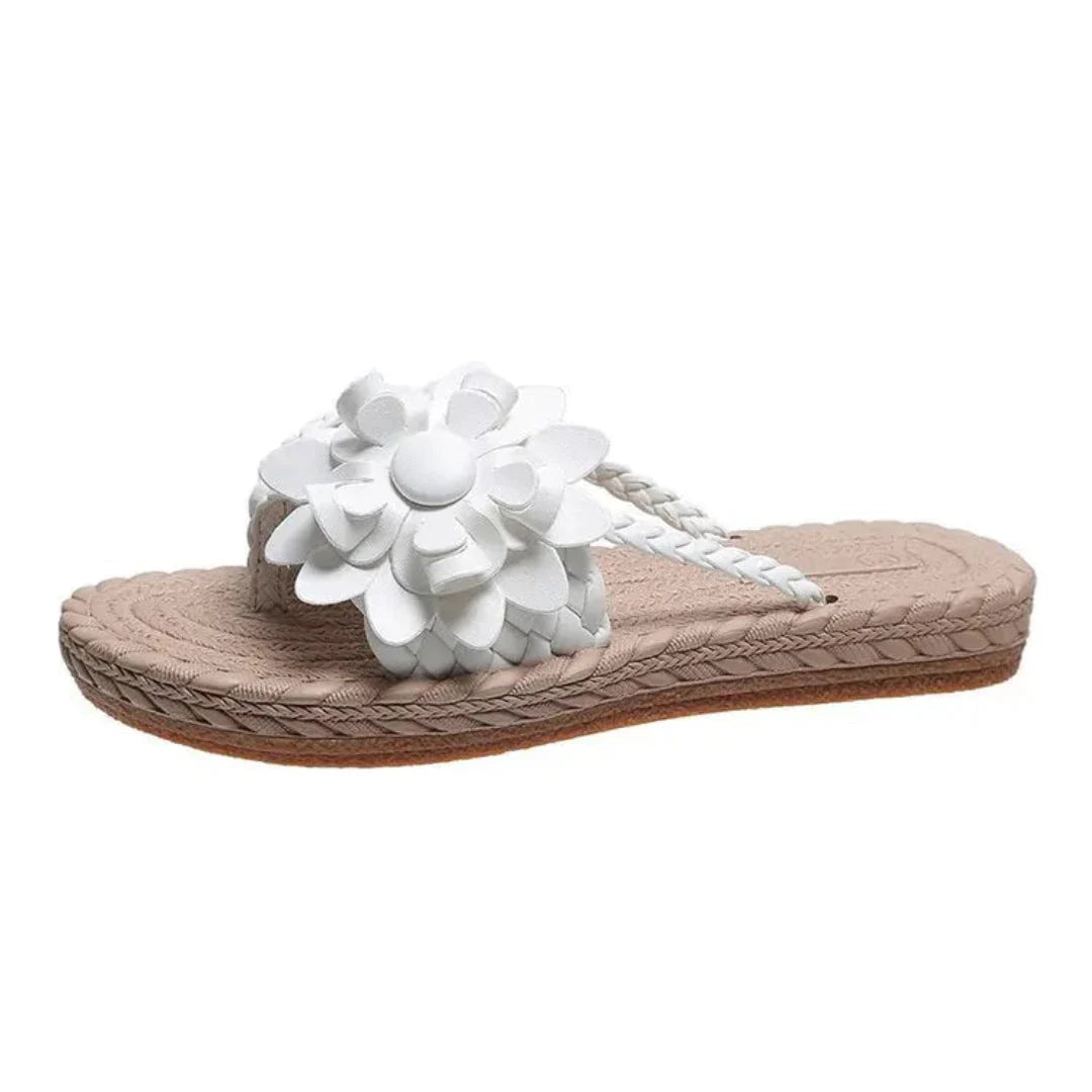 Women's woven slip-on flat sandals with bold 3D floral appliqué and braided boho strap