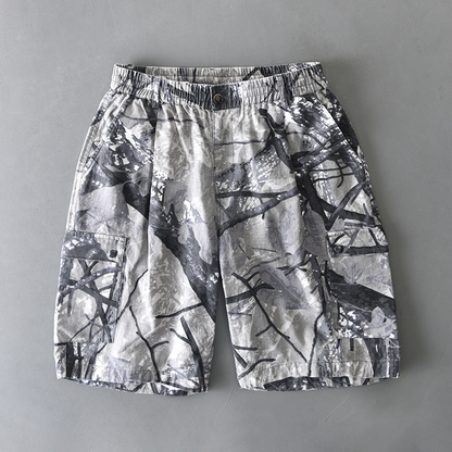 Men's distressed camouflage cargo shorts with dual button-flap pockets and elastic waist