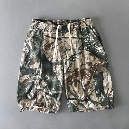 Distressed camouflage cargo shorts with elastic waist, button closure, and dual flap pockets