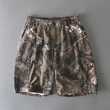 Distressed camo cargo shorts with elastic waist, button closure, and dual flap pockets for rugged style
