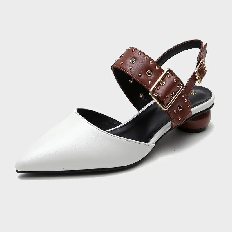 Women's studded strap sandals with metal stud embellishments, adjustable buckle, bold fashion-forward flat design