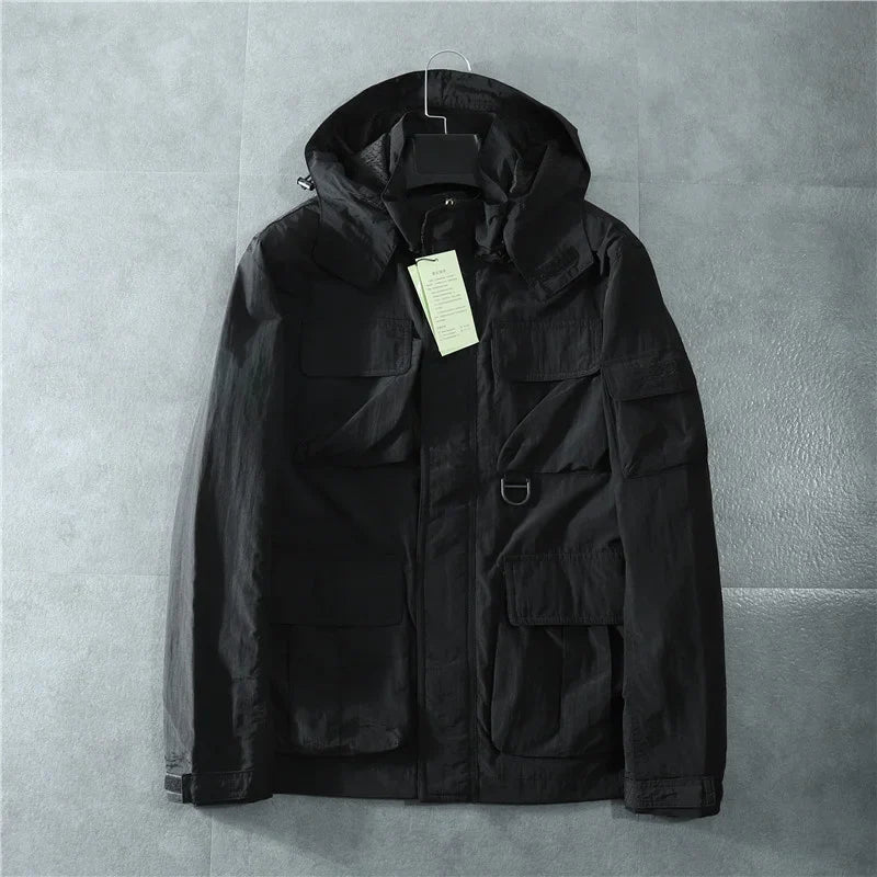 Black tactical jacket with removable hood, multi-pocket utility design and reinforced stitching
