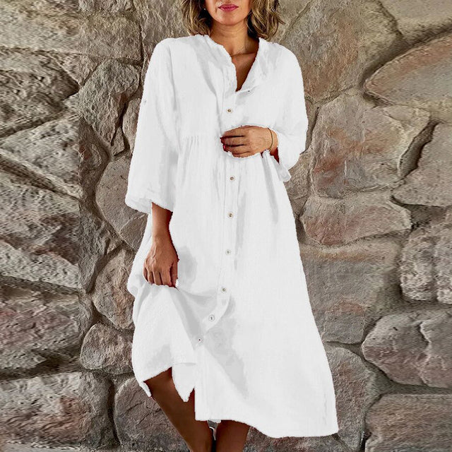 Women's flowy elegant midi dress in soft neutral tone with defined waist and flowing silhouette