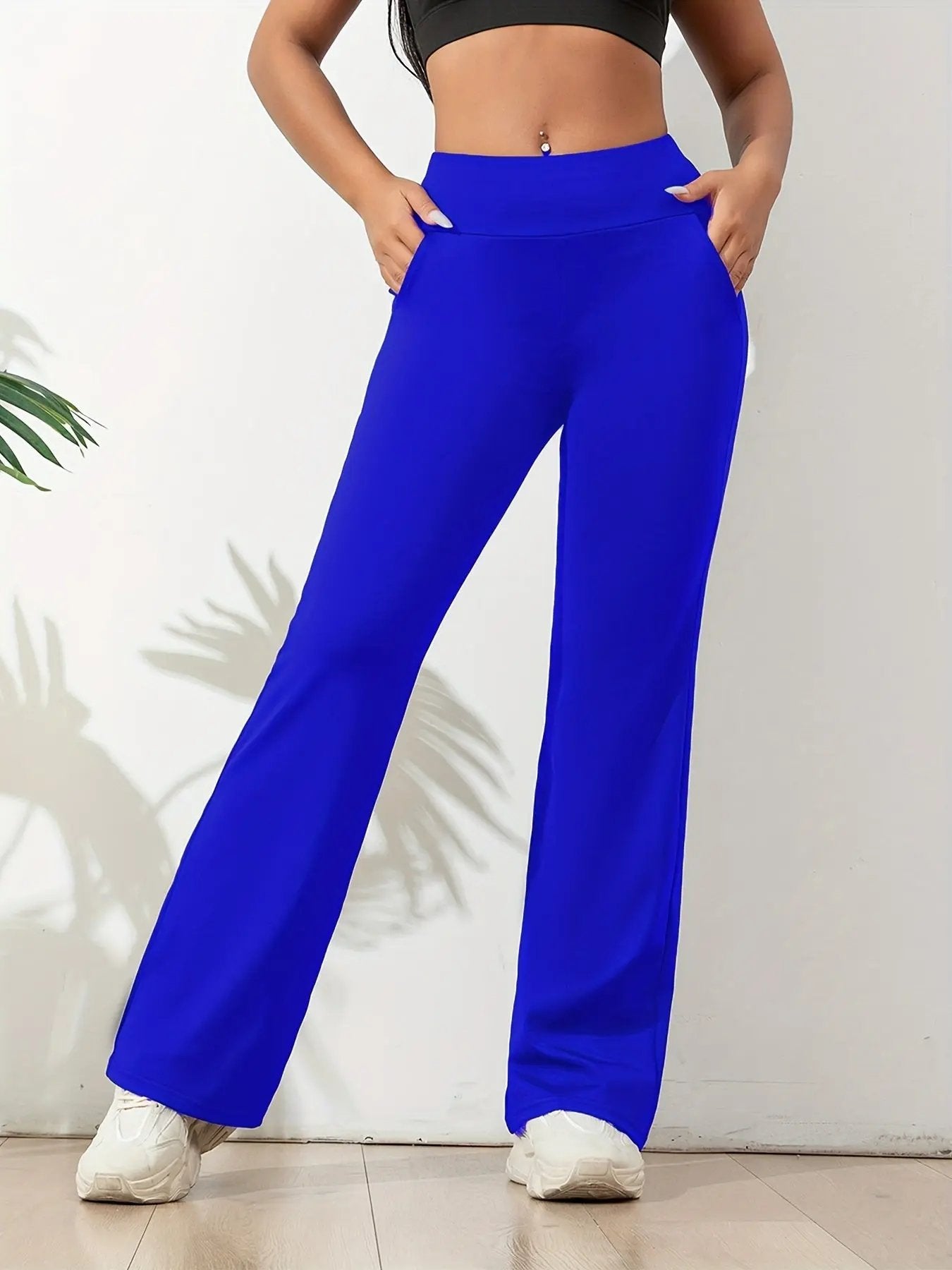 Women's black high-waisted yoga pants with wide waistband, slim fit, and side pockets