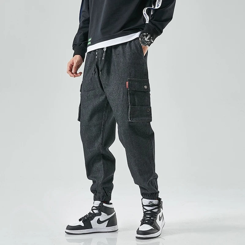 Dark-wash denim cargo joggers with tapered fit, elastic cuffs, and dual snap cargo pockets