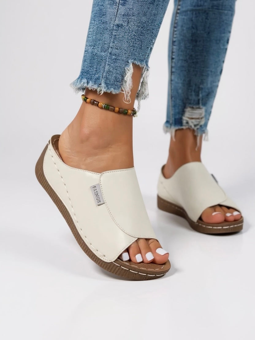 Women's platform cushioned slides in minimalist design with contoured footbed and lightweight sole