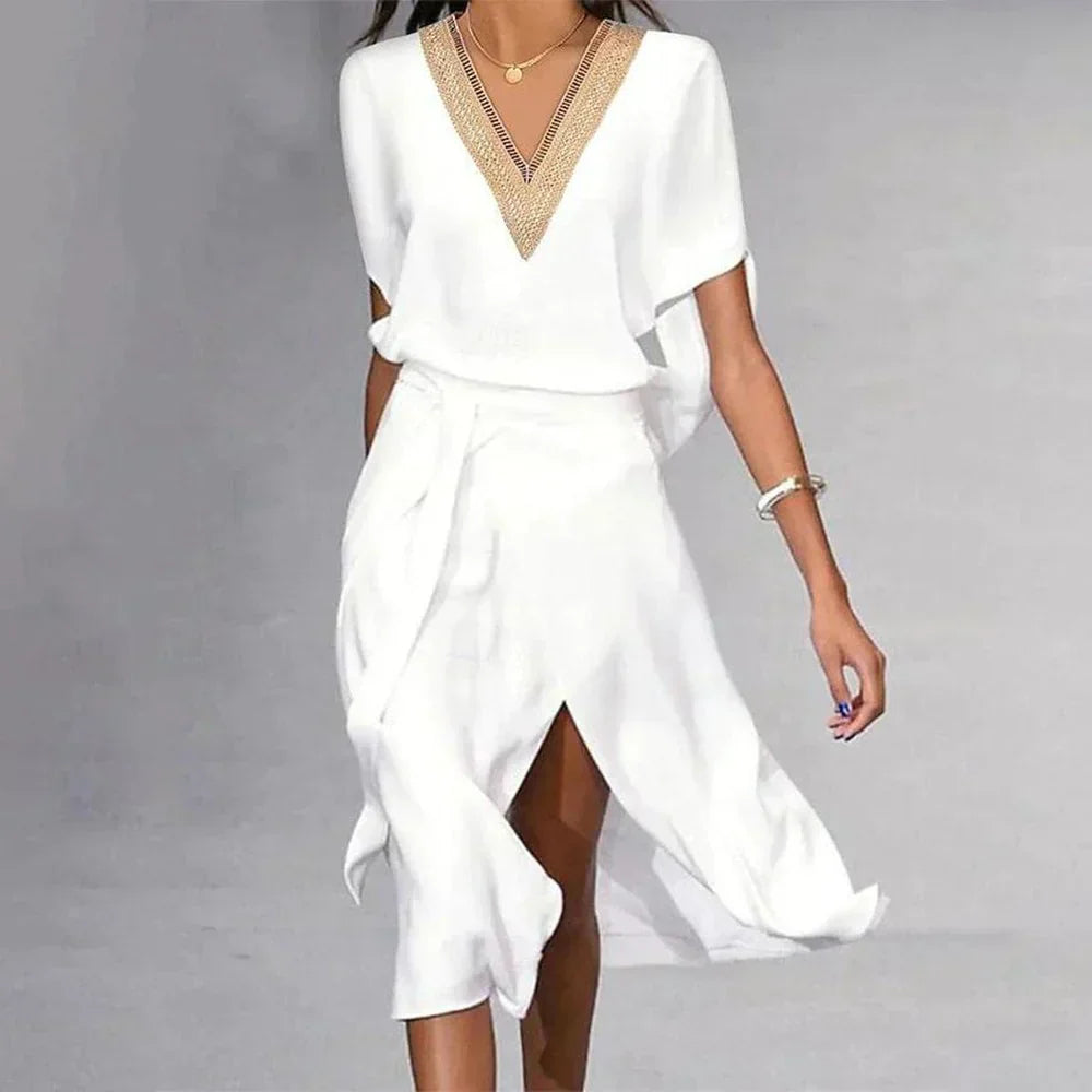 Women's white midi dress with gold V-neckline trim, batwing sleeves, and asymmetric wrap skirt