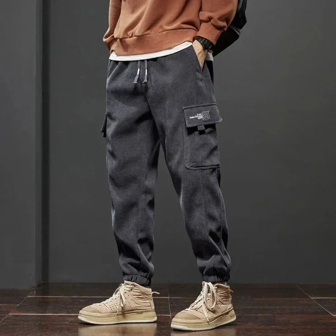 Men's fleece-lined tactical cargo pants with dual thigh pockets and ribbed ankle cuffs