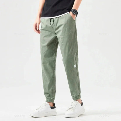 Men's olive utility cargo jogger pants with multiple functional pockets and drawstring cuffs