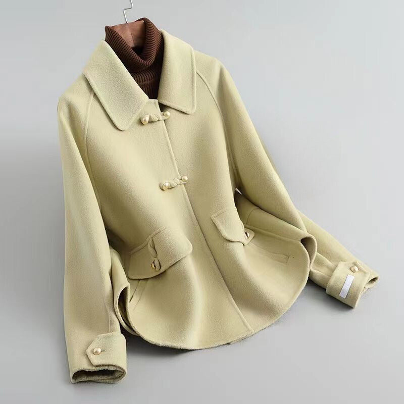 Ivory knit cotton-poly blend coat with lustrous pearl buttons, elegant Parisian-inspired silhouette