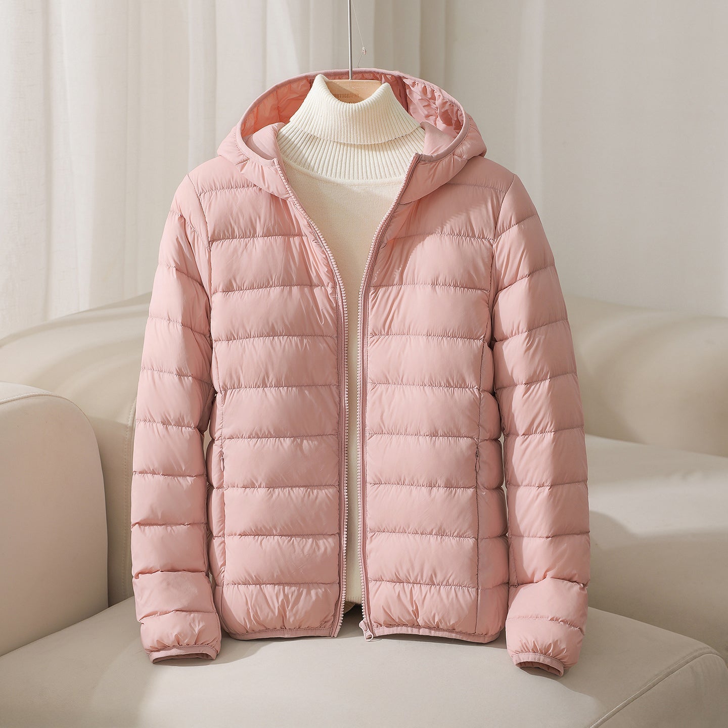 Lightweight hooded quilted down jacket in neutral tone with sleek horizontal stitching pattern