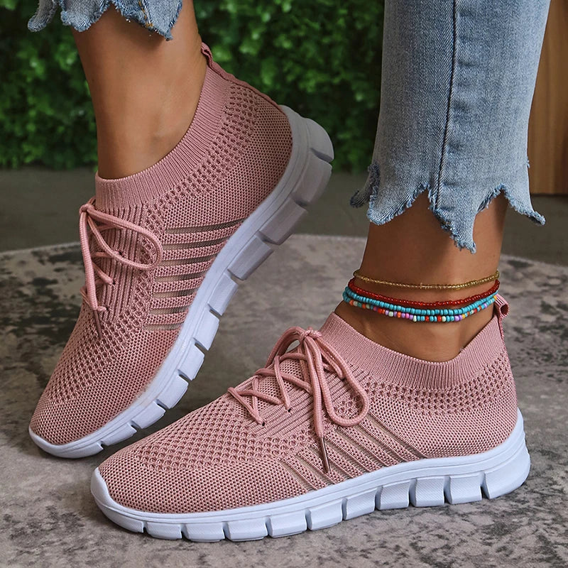 Women's white lightweight athletic sneakers with breathable mesh upper and casual sporty silhouette