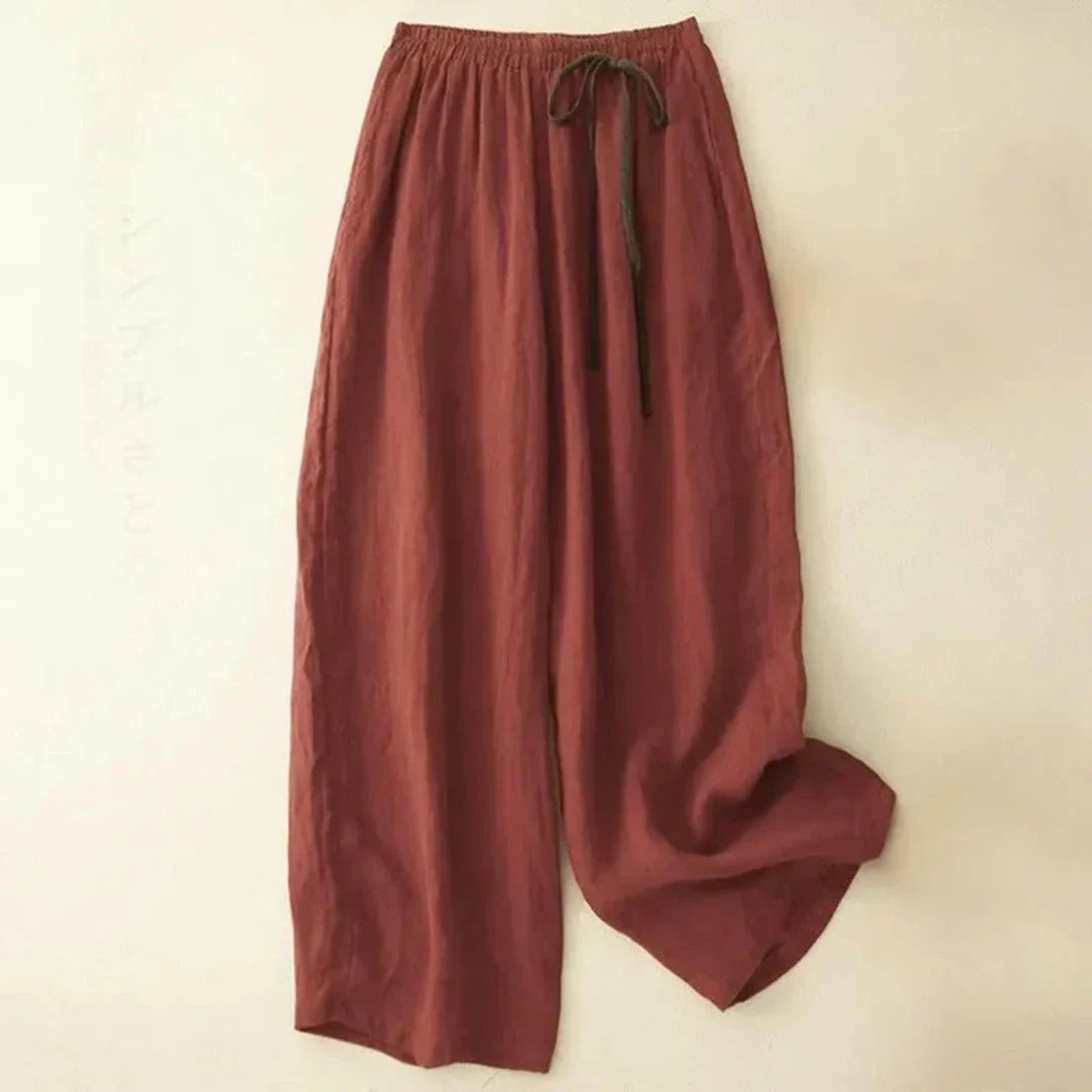 Beige wide-leg linen trousers with drawstring waist, relaxed mid-rise fit and breezy silhouette