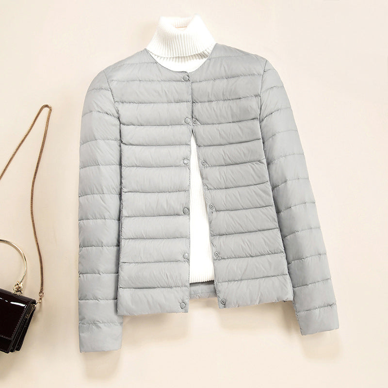 Lightweight quilted down jacket in neutral tone, minimalist round neckline, slim silhouette with thin insulating stitching
