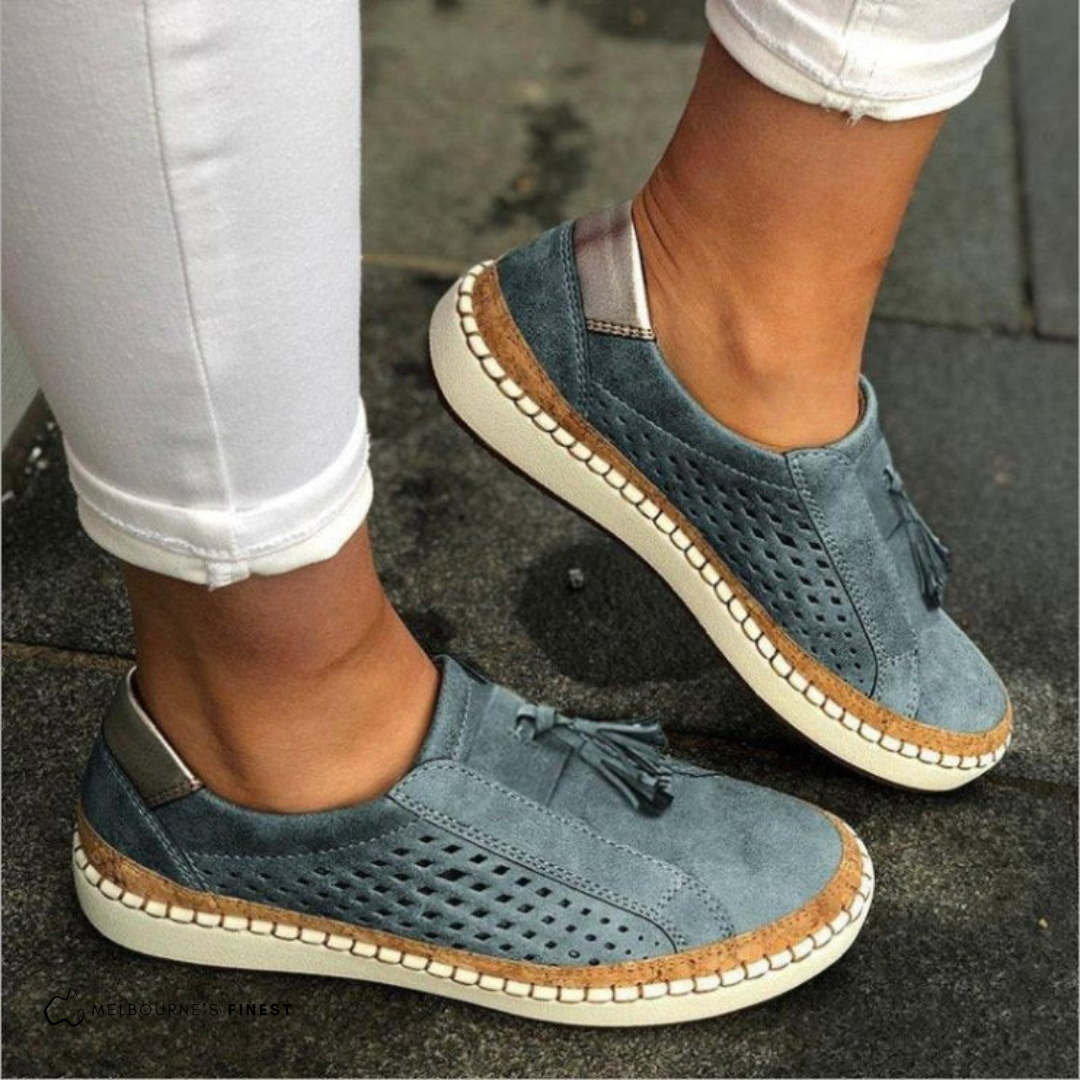 Women's beige suede slip-on loafers with perforated tassel accent and comfort cork sole