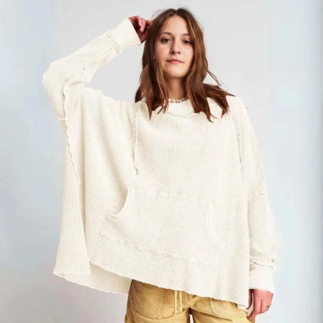 Oversized beige waffle-knit hoodie with drop shoulders, raw hem detail, and kangaroo pocket