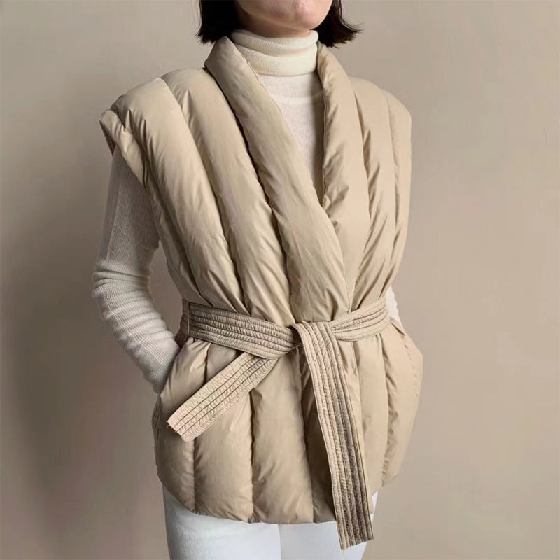 Quilted sleeveless puffer vest with adjustable textured belt for a cocoon silhouette