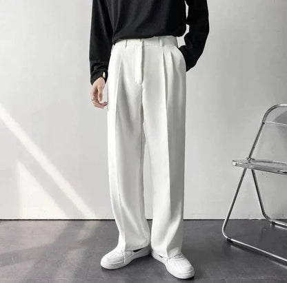 Matt wide-leg pants in neutral tone with tailored pleat detail and relaxed flowing silhouette
