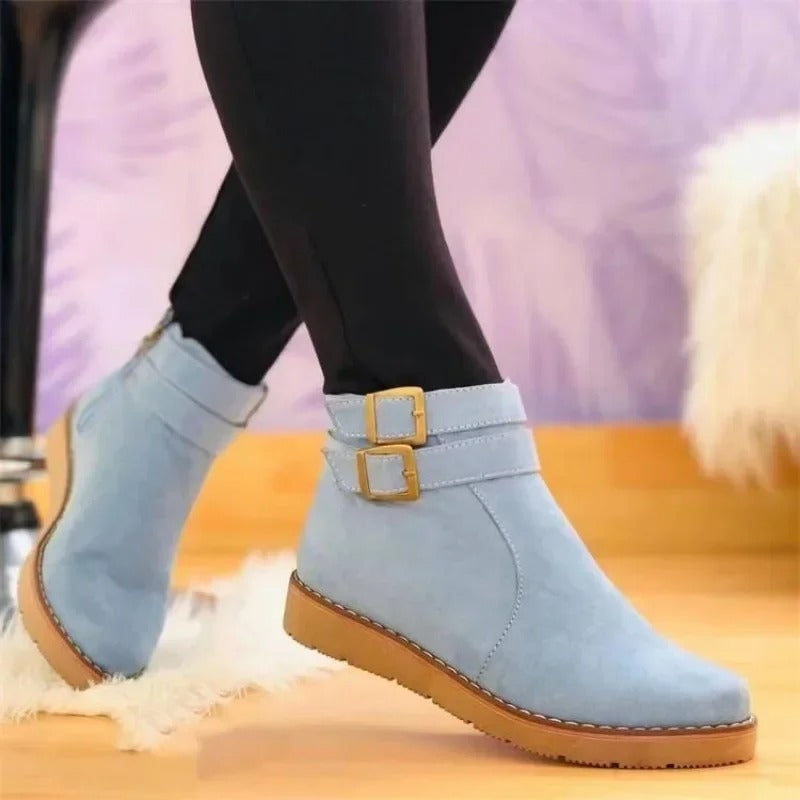 Women's black ankle boots with double buckle strap detail and sleek contemporary silhouette