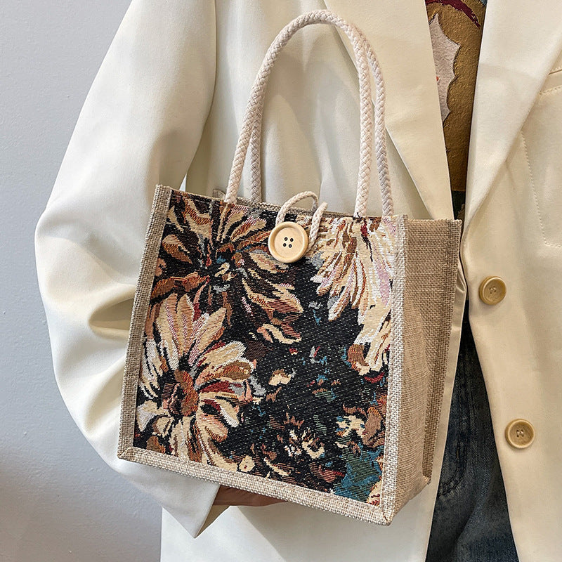 Heather floral woven tote bag in blooming multicolor twill with braided straps and bold button detail