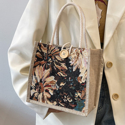 Heather floral woven tote bag in blooming multicolor twill with braided straps and bold button detail