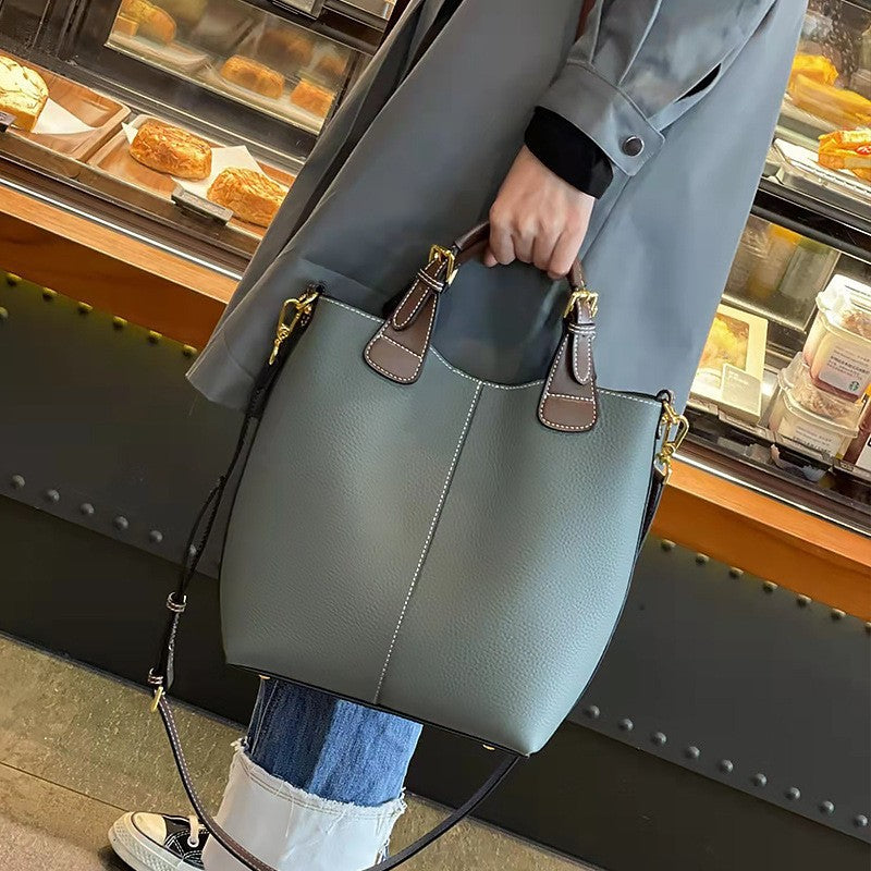 Structured black vegan leather tote bag with contrast handles and detachable crossbody strap