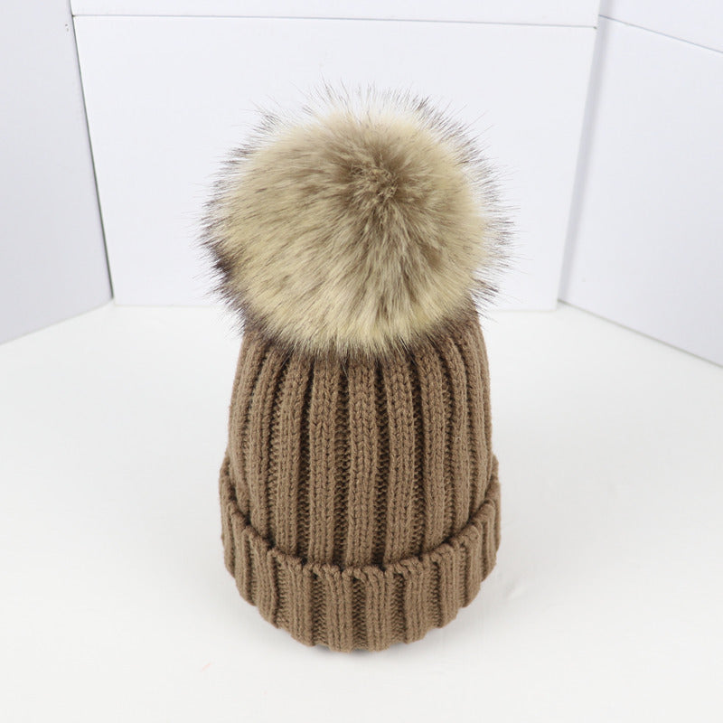 Classic cozy knit beanie in neutral tone with fluffy pom-pom accent, snug feminine winter fit