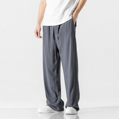 Men's loose-fit linen blend trousers in neutral tone with elastic drawstring waist for casual everyday wear